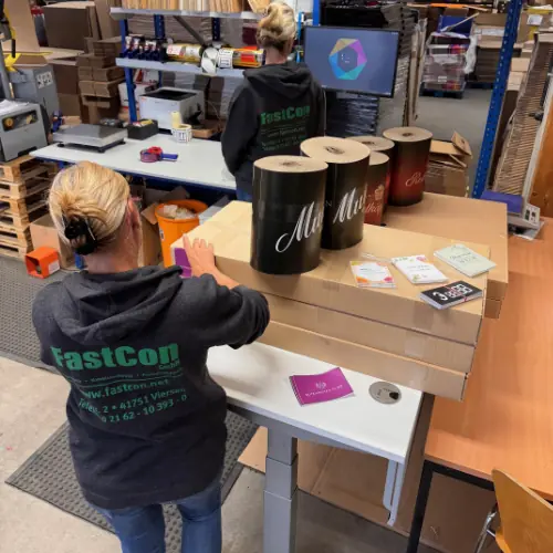 Mitarbeiterin konfektioniert Werbematerial am Packtisch